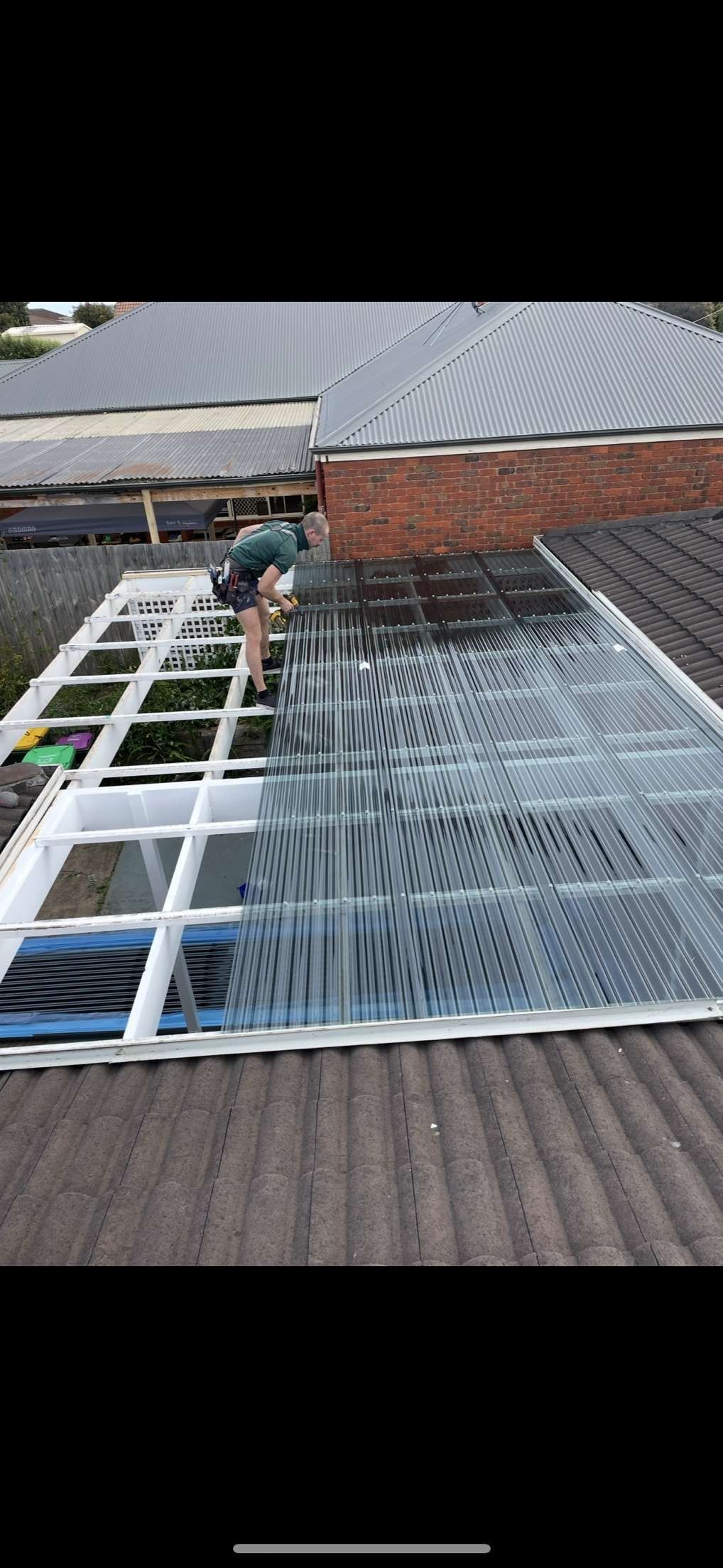 Worker installing polycarbonate roofing sheets